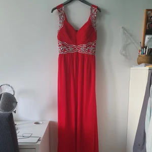 Festklänning  - Röd festklänning i jättefint skick. Använd en gång. Strech där bak så passar m-xl beroende på ens kroppsform på överdelen, ifall man har större byst exempelvis. Finns en matchande röd sjal också.
