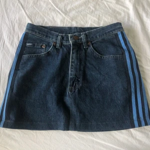 Jeanskjol Lee - En jeanskjol ifrån Lee, köpt secondhand. Ser ut som ny. På sidorna är det tre ljusblåa sträck av ett annat material.