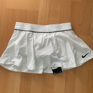 Tenniskjol - Nike tenniskjol vit, superfin. Man kan träna i den men också ha den i vardagen till en outfit. Prislapp kvar men för liten för mig. Xxs/xs