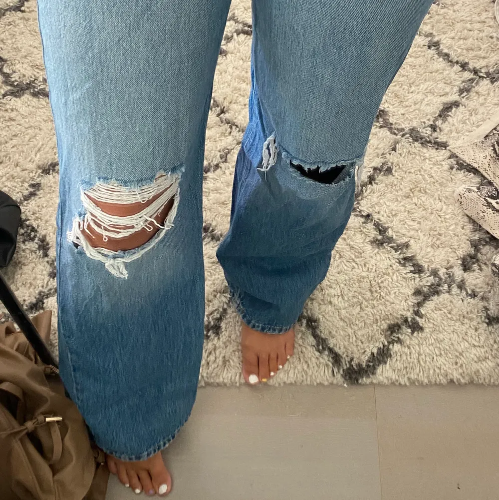 Mörkblå jeans med hål på knäna från Gina Tricot! Använda ett fåtal gånger, i bra skick förutom en slitning längst ner på höger ben. Frakt tillkommer, storleken är 34 men passar 36. Jeans & Byxor.