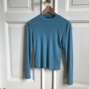 Långärmad topp från Bik bok strl S - Blå långärmad från Bikbok. Färgen är mest lik på bild 3, där man också ser hur tyget ser ut - lite struktur och liiite transparent nästan. Otroligt fin, men jag får acceptera att jag inte klarar syntettyg🙈  gott skick, sparsamt använd!