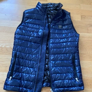  J Lindeberg väst  - Säljer en knappt använd  J Lindeberg väst. Passar både män och kvinnor, sitter lite tightare runt höften, men är hur mysig och varm som helst.