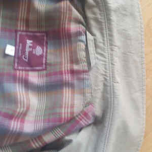 Trenchcoat kappa Mulberry klassisk herr - Mulberry Trenchcoat kappa eller rock, klassisk i fint skick. Dubbla rader knappar och kan knäppas både herr och dam. Den är köpt till mig (dam) som är 172 cm lång. Jag har använt den med uppvikta ärmar. Den är köpt för tio till tjugo år sedan, second hand, jag kan därför inte verifiera äktheten. Jag säljer den för halva summan jag betalade då. Den är hel och ren med många välsydda detaljer. Helfodrad och i behandlad bomull. Storlek herrstorlek S.  Längd från axel 120 cm. Bystmåttet är 110 cm. Skickas med posten, två kilo, alternativt lämnas i Umeå eller Stockholm (när ja kommer till Stockholm nästa gång) Betala gärna med swish så skickar jag spårbart med Postnord till angiven adress.  Meddela om Du vill köpa så lämnar jag ut telefonnummer för swish.