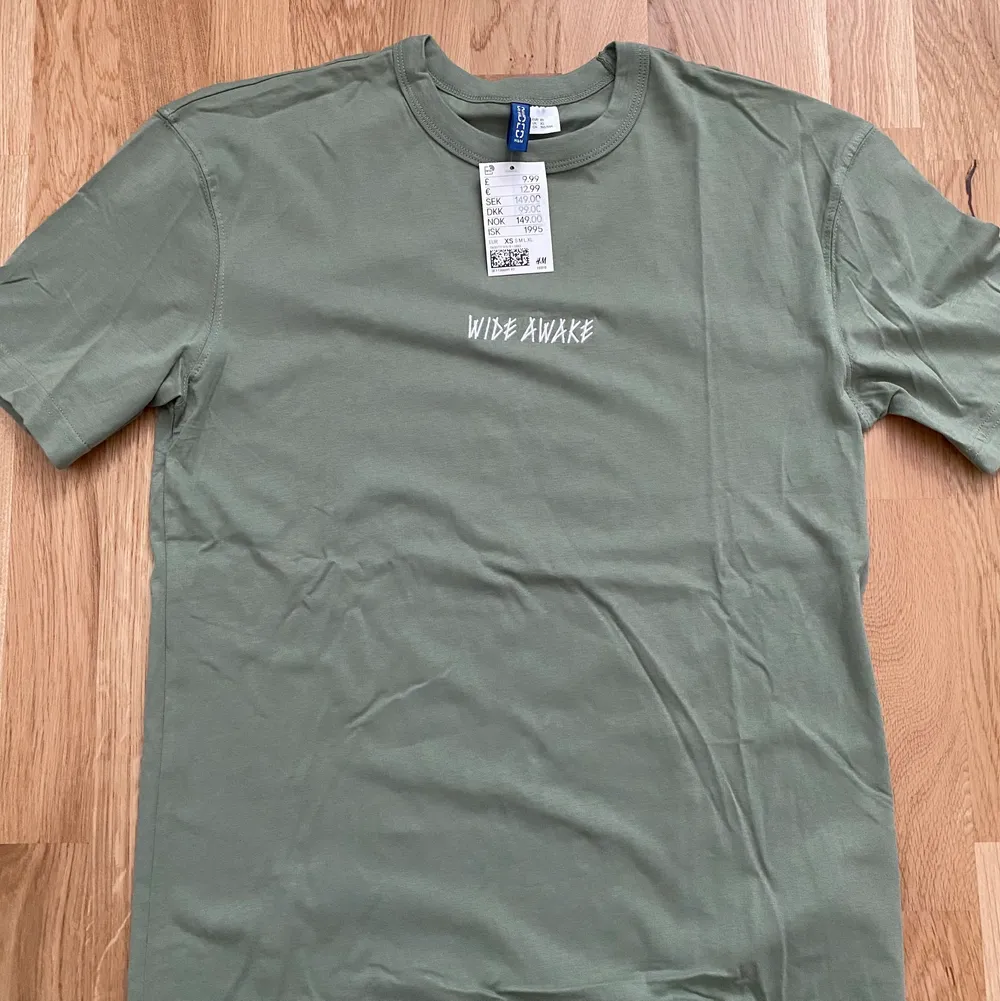 snygg grön tshirt med text från h&m. t-shirten är helt ny och i storlek XS. säljer eftersom den är för liten. köparen står för frakt. . T-shirts.