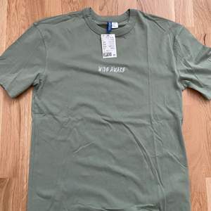 snygg grön tshirt med text från h&m. t-shirten är helt ny och i storlek XS. säljer eftersom den är för liten. köparen står för frakt. 