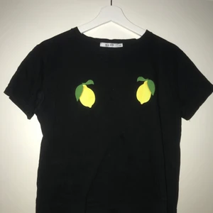 NA-KD t-shirt strl. XXS - En svart NA-KD t-shirt med citroner på varsin sida av brösten. Stor i storlek, skulle säga att det snarare är en S. 