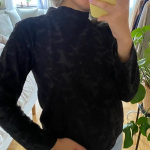 Svart halvpolo - Snygg svart halvpolo med blommigt mönster. Skön och i gott skick. Storlek M. Möts gärna upp eller skickar mot fraktkostnad!<3 