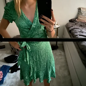 Omlottklänning - Säljer en jättefin omlottklänning från Bik bok som är grön med vita prickar på. Köpt för 400kr och därav 250kr plus frakt
