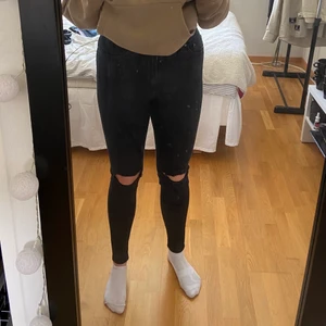 Svarta Jeans  - Svarta tajta jeans med håll vid knäna. Använda men i fint skick