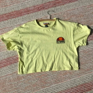 Ellesse croppad t-shirt✨ - En ljusgul Ellesse t-shirt med text fram och bak, skicket är som ny!