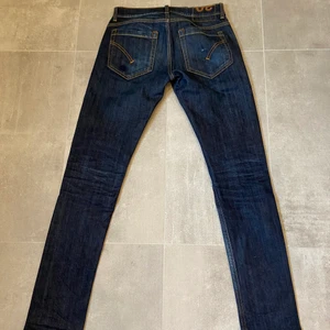 Dondup Jeans  - Ett par märkesjeans av bra kvalitet från Dondup. Jeansen är i storlek 29 och säljs pga att de inte längre passar mig. Nypris är 2300kr. Jeansen är överlag sparsamt använda och i bra skick. Dock finns en liten blå fläck vid vänstra bakficka men knappt något som syns, varav priset…