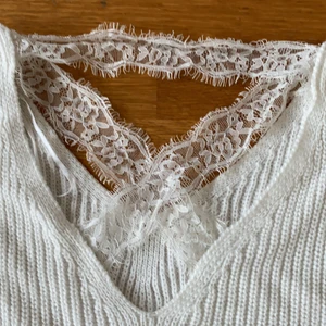 Vit stickad tröja - Stickad tröja med spets i ryggen. Väldigt fin o smickrande på. V-ringad där fram❤️