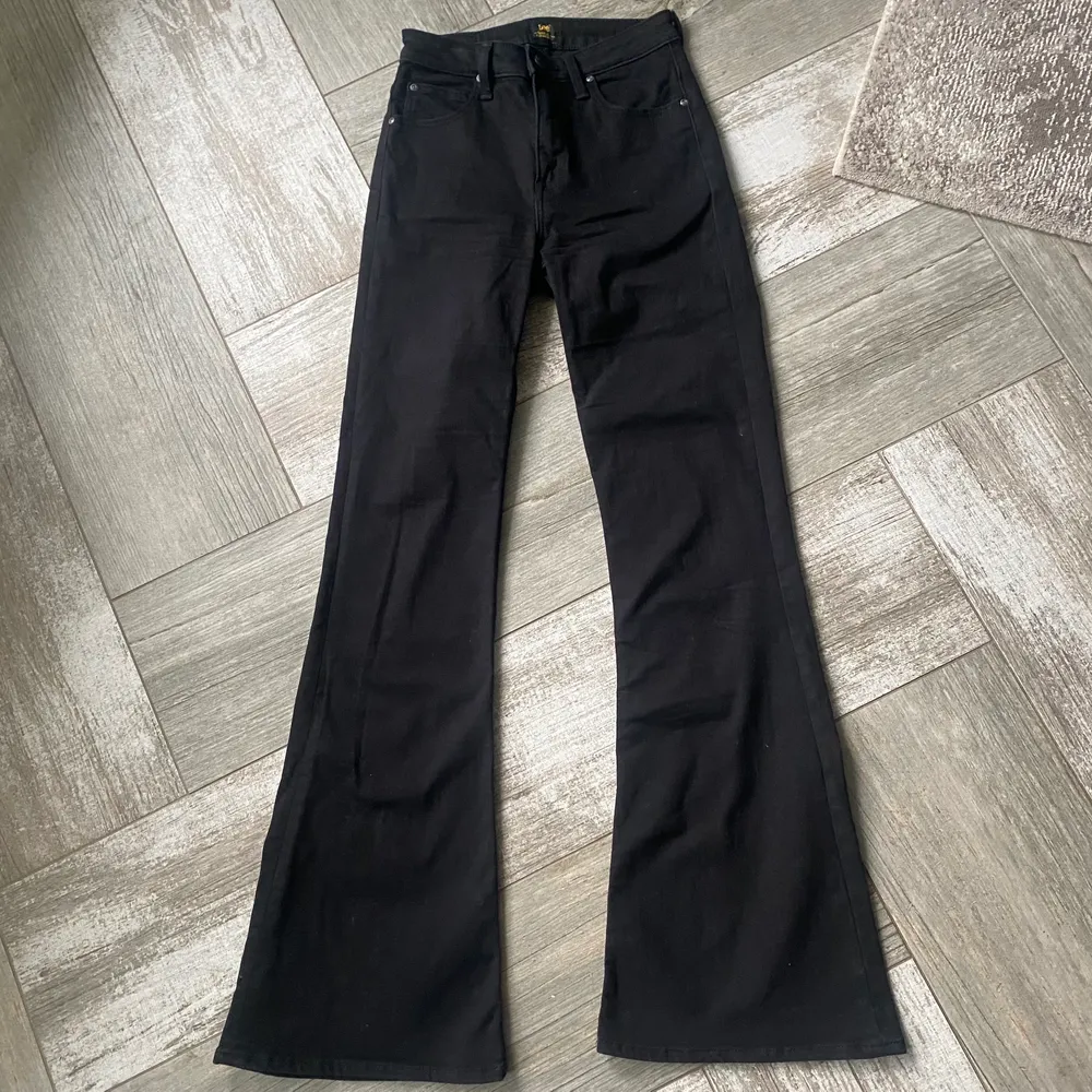 Ett par svarta bootcut jeans från Lee i bra sickt. Storlek W28 (höfterna) L33 (längden). Sitter ganska bra vid fötterna samt på längden och är ganska elastiska. Rekommenderas upp till 177 cm lång person, är du längre än så så kommer jeans att vara kortare.. Jeans & Byxor.