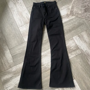 Lee Jeans  - Ett par svarta bootcut jeans från Lee i bra sickt. Storlek W28 (höfterna) L33 (längden). Sitter ganska bra vid fötterna samt på längden och är ganska elastiska. Rekommenderas upp till 177 cm lång person, är du längre än så så kommer jeans att vara kortare.