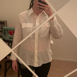 Vit skjorta - Mjuk, lätt, tunn vit skjorta med två stora bröstfickor. Skitsnygg och superskön. Älskar den men säljs för den är lite tight runt mina armar.