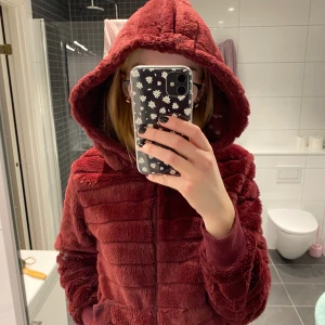 Vinröd Teddy kofta - En jättemysig Teddy kofta med en stor mysig luva. Storlek S. Säljer då den inte kommer till användning!