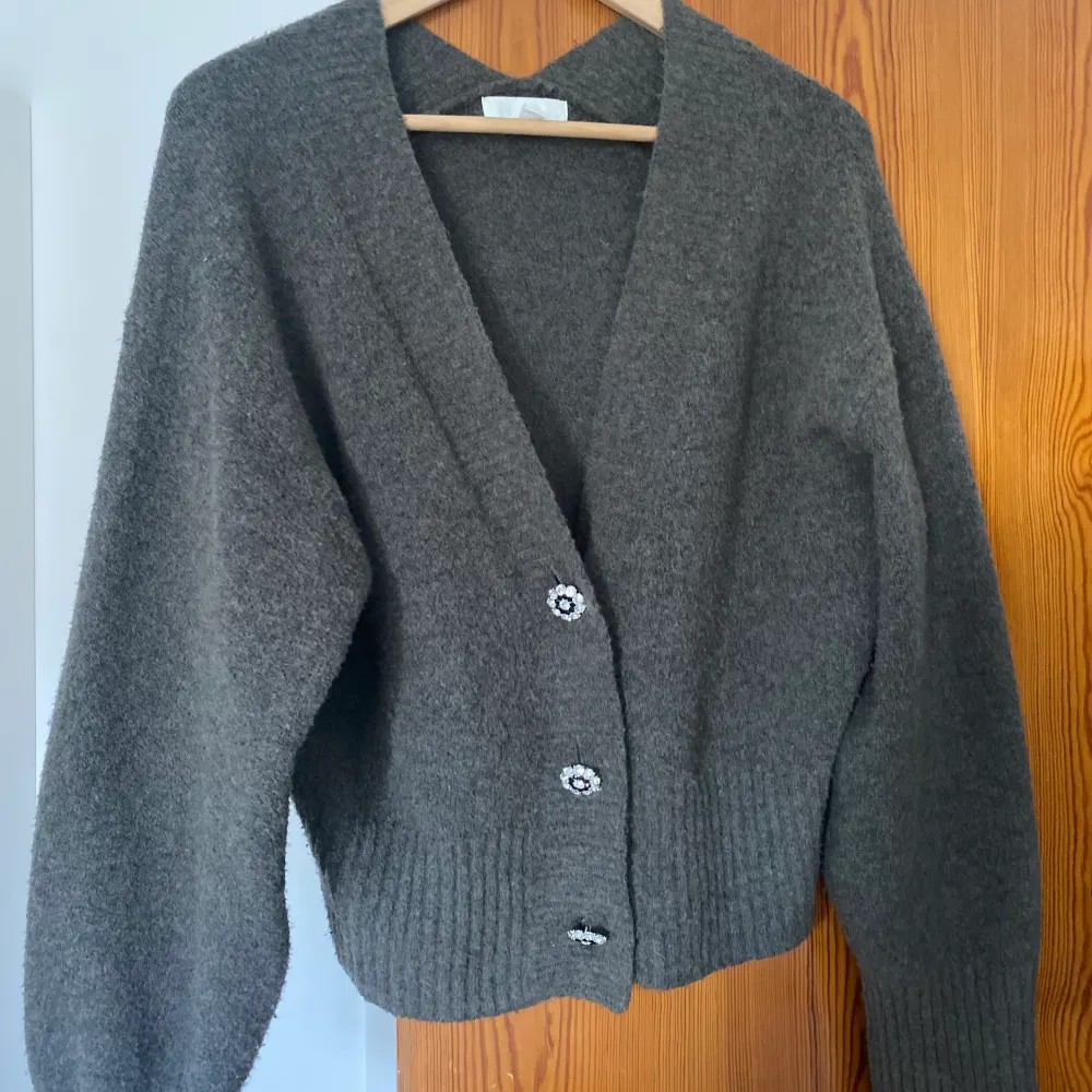 En finstickad grå kofta med snygga knappar! Köpt på hm förra året och tröjan är i ganska bra skick. Storlek XS men den är stor i storleken💕⚡️. Tröjor & Koftor.