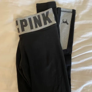 Träningstights PINK (Victoria’s Secret) - Svarta träningstights ifrån PINK. Grå och svart detalj med PINK text i midjan. Storlek xsmall men väldigt stretchiga, så skulle säga att de passar även större storlek. Nypris: 60$ Fraktavgiften står köparen för!💫 