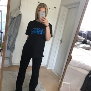 Storlek S - Svart t-shirt med blått tryck, köparen står för frakten