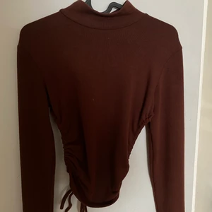 Polo tröja  - En fil mörkbrun tröja med en öppning i ryggen, passar bra till vardag och fest. 