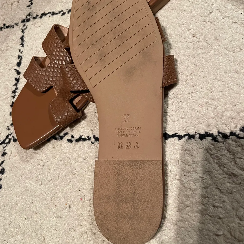 Jättefina bruna Hermes-liknande sandaler som är köpta i Brasilien. Säljer då storleken är för liten därav knappt använda. Stl 37. Frakten kostar 48 kr 🌸. Skor.