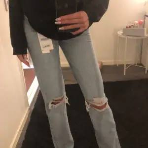 Ett par ljusa jeans från Zara med slitningar på knäna, stolk 32. Säljer då jag råkade dubbelbeställa dessa så har 2 av samma. Helt nya med prislapp på! Köparen står för frakten 