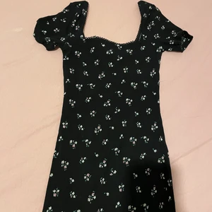 figurformad klänning i svart med blomdet - nyskick