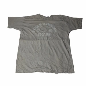 Powerhouse Gym - Vintage T-shirt  - En riktigt bra tröja från dig som älskar att gymma och vill gå dit med stil. Har ett lite undansväng coolt grafiskt tryck som ligger över bröstet. Är thriftad och kommer troligtvis med tanke på färgerna och trycket att gymmet är riktigt Nice. 