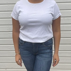 Ribbad topp - Ribbad vit t-shirt från H&M! Skulle säga att t-shirten passar en M-L, (modellen bär vanligtvis S-L. Toppskick eftersom den aldrig är använd. 🤍