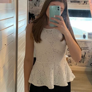 Spets topp - Ett fint vitt spets linne. Fram och i den lilla ”kjolen” är det ett lager vitt tyg med bak på ryggen är den genomskinlig med bara spets. (Se bild 3). Ägd av min syster innan mig men den är använd få gånger och är i bra skick. Min syster har dock skrivit (C.T) på lappen i tröjan men det är inget som märks. Eller påverkar toppen på något vis. 