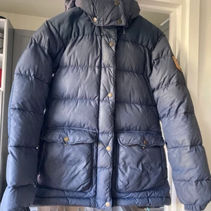 Fjällräven dunjacka - modell: Övik  - Dunjacka från Fjällräven. Modellen heter Övik. Storlek XS. Använd men i gott skick! Kan hämtas på Kungsholmen eller skickas mot leveransavgift :) Bara höra av sig vid frågor eller om fler bilder önskas. 
