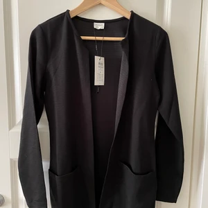 Kofta - Svart knälång kofta säljes. Aldrig använd! Nypris: 280kr men säljer för 150kr. Går att frakta.