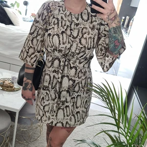 Klänning  - Väldigt fint skick. Tunnt skönt material och ändå ej genomskinlig. Använd ett fåtal gånger. Knytband under byst. Dragkedja i ryggen. Raka vida ärmar. Strl 8. 