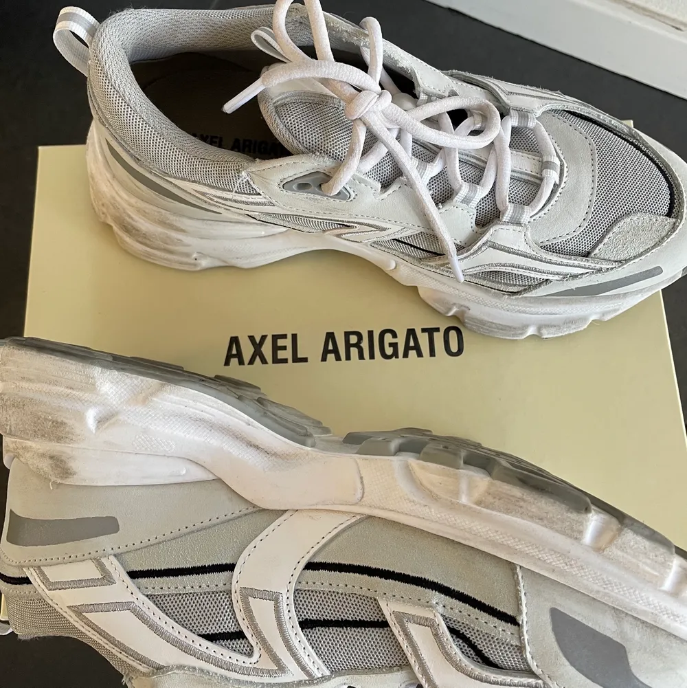 Säljer ett par Axel Arigato sneakers köpta i våras. Storlek 39. Är lite skavda inne men inget som syns. (Fått genom att skorna gått emot varandra) använda sparsamt.. Skor.