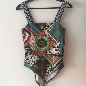 Oanvänd body från River Island - Nyskick. Oanvänd. Elastiska band. Stl. 32.  Säljes pga för liten i storleken.                        Vill du sticka ut i coolt mönster så vill denna body ha dig som ny ägare! 🌸