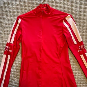 Sportig topp från J Lindeberg  - Sportig röd tight långärmad topp från J Lindeberg. Sitter jättefint på och har fina detaljer i nacke och hals. 