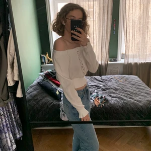 Vit sommar topp - Axelbandslös/strappless topp, långa ärmar, genomskinlig rand i mitten. Resår runt axlarna, midjan och vristerna. Storlek 38. Kan hämtas upp i Vasastan eller postas. Köpare betalar för post avgifter.