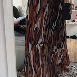 Mönstrad Långkjol med gulddetaljer  - En superfin långkjol i olika färger med resårband vid midjan med gulddetaljer!! Man kan vika upp kanten om man önskar att den blir kortare! Passar storlekarna medium och small