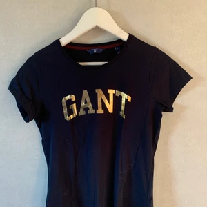 Marinblå gant t-shirt storlek S - Marinblå t-shirt med guldtryck, fint skick.