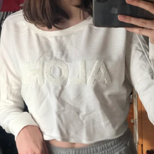 Croppad tröja - En vit långärmad croppad tröja med diskret text på. Är i storlek S men passar både XS och M med.