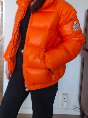 Orange Vintage Mythic Puffin Pyrenex (unisex)  - En jättefin orange Vintage Mythic Puffin Pyrenex jacka i väldigt bra skick. Storlek M men kan även användas av S.  Originalpriset är 5000kr  Se hemsidan: https://pyrenex.com/en/products/unisex-down-jacket-vintage-mythic-puffin