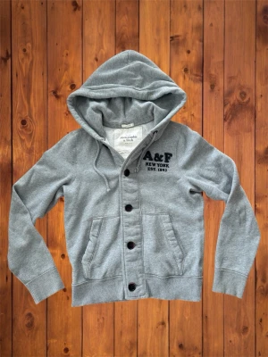 Vintage Abercrombie&Fitch hoodie (sällsynt) - Säljer denna vintage sällsynta och asfeta hoodien/cardigan från Abercrombie&Fitch. Riktigt fet och den är i väldigt bra skick och har en riktigt fet logga vid bröstet. Storlek är L men passar M se måtten nedan B=64cm A=54cm