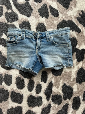 Blåa lågmidjade jeansshorts från Gina Tricot - Säljer ett par lågmidjade ljusblåa jeansshorts från Gina Tricot i storlek 146 (köpta på barnavdelningen). Väldigt sparsamt använda så skicket är super!😁🙌