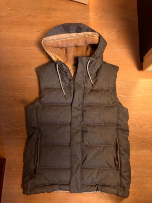 Rawwear Väst - Säljer en otrolig grå väst med luva och lite skön najs päls eller vad man säger i luvan, den är grå och är i ett skönt najs kvalitativt material riktigt snygg, storlek S passar M. NYSKICK kom privat för mer bilder eller frågor 