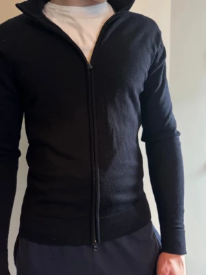 Mörkblå ziptröja - Snygg mörkblå ziptröja med en hel dragkedja framtill. Tröjan har en smal passform och är tillverkad i ett mjukt material som passar perfekt till lager-på-lager. Enkel och stilren design utan synliga loggor.