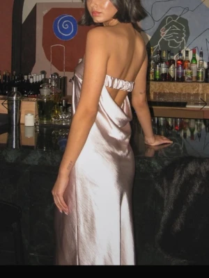 Balklänning  - Champagne rosa bandeau satinklänning från NAKD💕Storlek 32 men passar även 34. Jag brukar ha 34/36 och den passade perfekt!!   Kom gärna med prisförslag och skriv för frågor!!  Har tyvärr liten fläck samt liten repa (se sista bilden), men annars gott skick!! Det kan förekomma nån mer vattenfläck men inte vad jag ser nu🥲💕det syns knappt tycker jag, bara i vissa ljus   Bild 1 och 2 är från hemsidan 💕