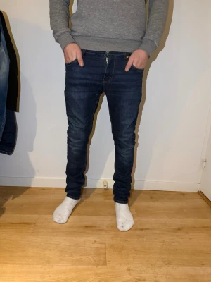 Levi's 512 Slim Taper jeans mörkblå - Säljer ett par Levi's 512 Slim Taper jeans i mörkblå tvätt. Jeansen är rätt så användna. De har smal passform med avsmalnande ben, klassiska fem fickor och gul kontrastsöm. Jeansen är tillverkade i jeansmaterial och har dragkedja och knapp framtill.