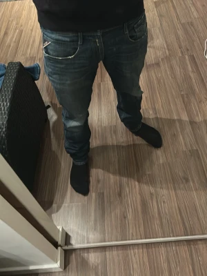 Blåa Replay Anbass jeans herr - Säljer ett par blåa Replay Anbass jeans med snygg tvätt och klassisk femficksmodell. Jeansen har normal midja, smal passform och slitna detaljer för en avslappnad look. Perfekta för dig som gillar streetwear och vill ha ett par bekväma jeans.