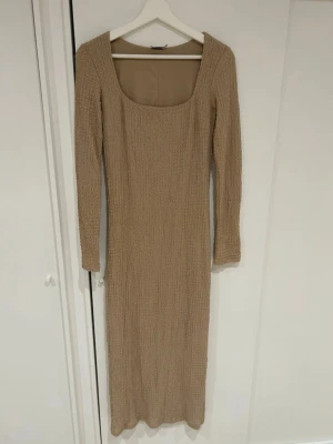 Beige klänning  - Lång klänning med lite struktur i materialet. Använd 1 gång