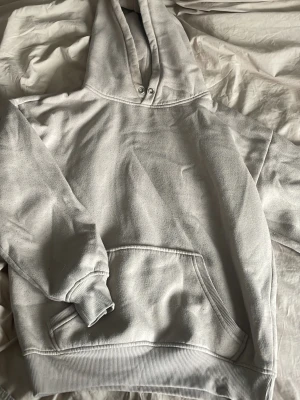  hoodie med ficka framtill - Säljer en enkel och stilren  hoodie med huva och dragsko. Hoodien har en stor magficka och ribbade muddar vid ärmar och nederkant. Perfekt för en avslappnad och casual look. Materialet känns mjukt och bekvämt.